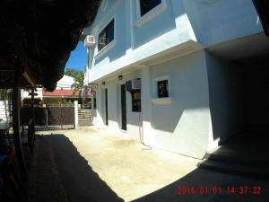 a white building with a door and a courtyard at AA TRAVELLERS PAD in Laoag