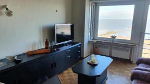 a living room with a television on a dresser at Appartement Knokke Zeedijk in Knokke-Heist
