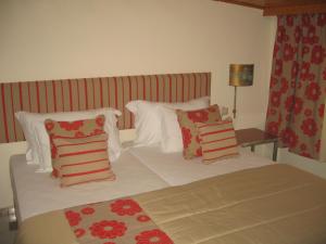 a bed with red and white pillows on it at Hospedaria Frangaria in Faro