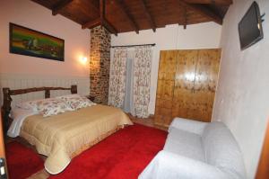 een slaapkamer met een bed en een bank bij Pasithei in Karpenisi