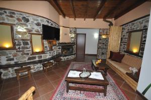 a living room with a couch and a stone wall at Pasithei in Karpenisi