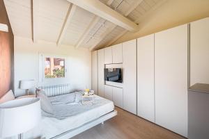 a bedroom with white cabinets and a bed at Birdie 59 Apartment by Wonderful Italy in Soiano del Lago