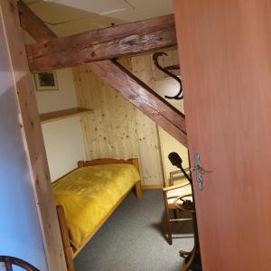 een kleine kamer met een stapelbed met gele lakens bij La Clé des Champs in Les Fourgs