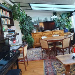 a dining room with a table and some plants at La Clé des Champs in Les Fourgs