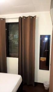 a bathroom with a shower curtain and a window at Hostel Dodero in Liberia