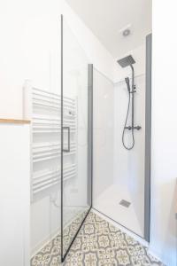 a bathroom with a shower with a glass door at Le Magnifique Appart'Hotel Le Gatsby in Saint-Quentin