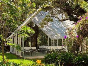 a greenhouse with tables and chairs in a garden at Villa Ilusion in San Jerónimo