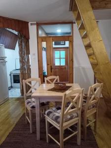 ein Esszimmer mit einem Holztisch und Stühlen in der Unterkunft Vikend kuca Bela Reka in Brzeće