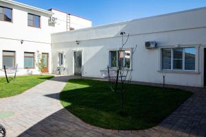 a white house with a lawn in front of it at Гостевой дом Villa Aila in Mineralnye Vody