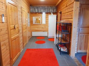 a bathroom with wooden walls and a red rug at Lake Inari Mobile Cabins in Inari