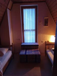 ein kleines Zimmer mit zwei Betten und einem Fenster in der Unterkunft Vikend kuca Bela Reka in Brzeće