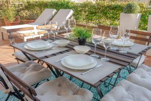 a wooden table with plates and wine glasses on it at Apartamento Bajo en Isla de la Toja in Isla de la Toja