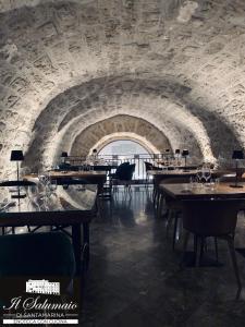 a dining room with tables and a stone wall at PALAZZO SANTAMARINA Luxury Suite & Spa in Palermo