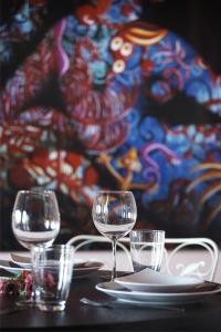 une table avec des verres et des assiettes sur une table dans l'établissement Art Hotel Mirtali, à Dodoni