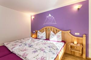 a bedroom with a bed with a purple wall at Ferienwohnung Amethyst in Mittenwald