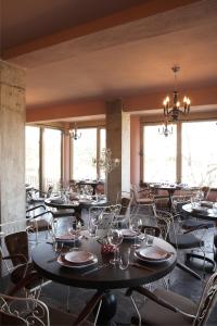 a dining room with tables and chairs and windows at Art Hotel Mirtali in Dodoni