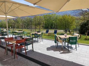 a group of tables and chairs with umbrellas at Hotel Bellinzona Sud Swiss Quality in Monte Carasso