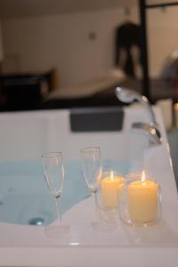 two wine glasses and two candles on a table at Entre Nous Le Maréchal in Saumur +29 photos