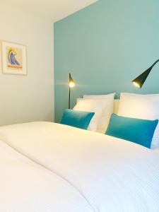 a bedroom with two beds with blue and white pillows at HOSSEGOR Plage & Golf in Hossegor