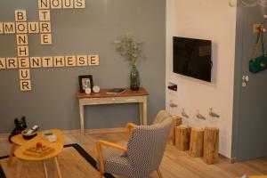 a living room with a table and a chair at Entre Nous Le Maréchal in Saumur