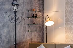 a lamp and a couch and a wall with shelves at Apartment near center in Klaipėda +31 photos