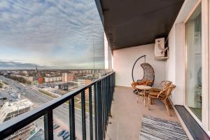 a balcony with a table and chairs and a view of a city at Apartment near center in Klaipėda