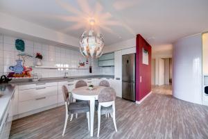 a kitchen with a table and chairs and a chandelier at Apartment near center in Klaipėda