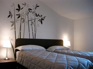 a bedroom with two beds and two lamps and a bedspread at Low Cost Ferrara in Ferrara
