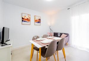a dining room with a table and chairs and a tv at Cubo's Urban Miranda Apartment in Cártama