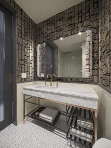 デンバーにあるThe Slate Hotel Denver Downtown, Tapestry by Hiltonの洗面台と大きな鏡のあるバスルーム