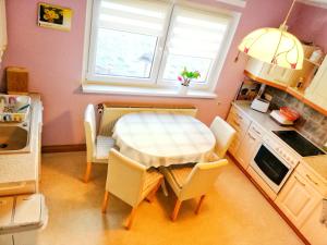 a small kitchen with a white table and chairs at Ferienwohnung Zschorlau/Erzgebirge 03771 479123 in Zschorlau