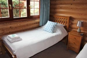 a bedroom with a bed with two towels on it at Osiers Country Lodges in Diss