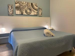 Hotel Ristorante Miramare في بيزارو: سرير في غرفة نوم مع صورتين على الحائط