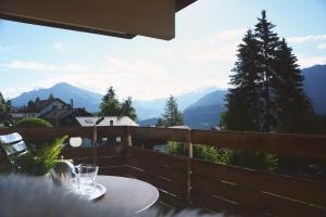 a table on a balcony with a view of mountains at Roc d'Orsay F72 in Leysin