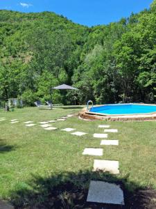 un patio trasero con piscina y mesa en La Meridiana, en Frontone