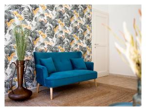 a blue chair in a room with a floral wallpaper at Il Grottino Relais & Spa in Gualdo Cattaneo