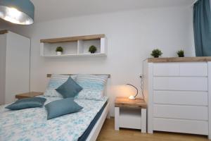 Dormitorio pequeño con cama con almohadas azules en Apartament Błękitny-Centrum Racibórz, en Racibórz