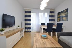 a living room with a television and a table with chairs at Apartament Błękitny-Centrum Racibórz in Racibórz