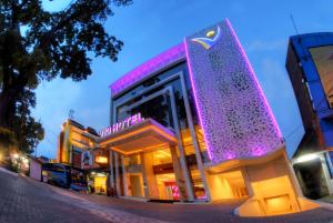 a building with a purple facade on a street at Vio Cihampelas in Bandung