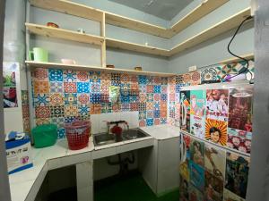 a kitchen with a sink and tiles on the wall at 3cuhomestay in Thinh Làng