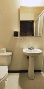 a bathroom with a sink, toilet and mirror at Hostal de Las Américas in Oaxaca City