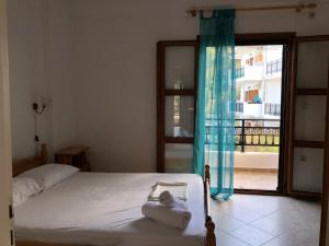 1 dormitorio con cama y ventana grande en Nikos Apartments A3, en Gialiskari