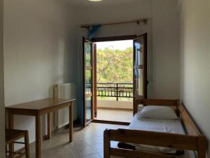 1 dormitorio con cama, escritorio y ventana en Nikos Apartments A3, en Gialiskari