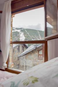 a bedroom window with a view of a mountain at Apartament Ninot Bonito apartamento con vistas a la X de Grandvalira in El Tarter