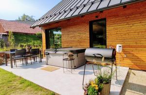 a barbecue grill on a patio next to a house at BIKE HAVEN - jacuzzi - mountain biking and hiking in Nové Město pod Smrkem