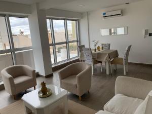 uma sala de estar com um sofá, uma mesa e cadeiras em Espacio Chacabuco em Comodoro Rivadavia