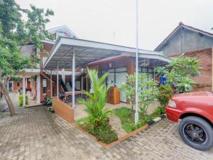 a red car parked in front of a house at SUPER OYO 90758 D Kost In Kandri Semarang Syariah in Semarang