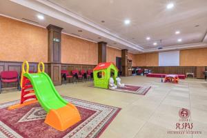a childrens play area with a green slide and chairs at Апартамент Лукс в Спа Хотел Свети Спас in Velingrad