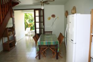a dining room with a table and a refrigerator at Résidence Sucrerie Motel - Les Anses-d'Arlets - Martinique in Les Anses-dʼArlets