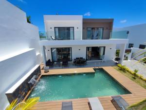 a villa with a swimming pool and a house at Villa Cap Malheureux, piscine privée, salle de jeux in Petit Raffray